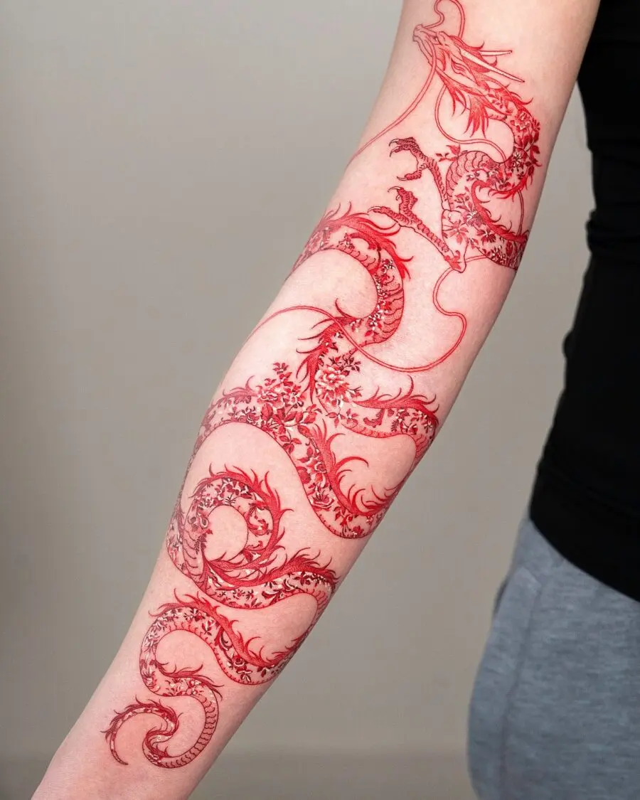 Intricate red ink dragon tattoo on forearm