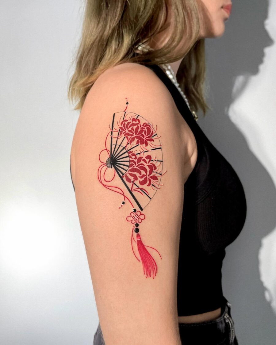 Elegant red ink fan tattoo with floral accents