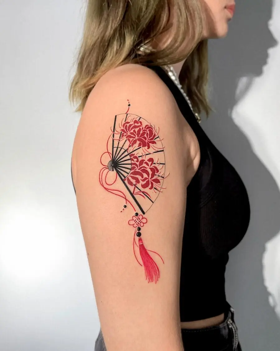 Elegant red ink fan tattoo with floral accents
