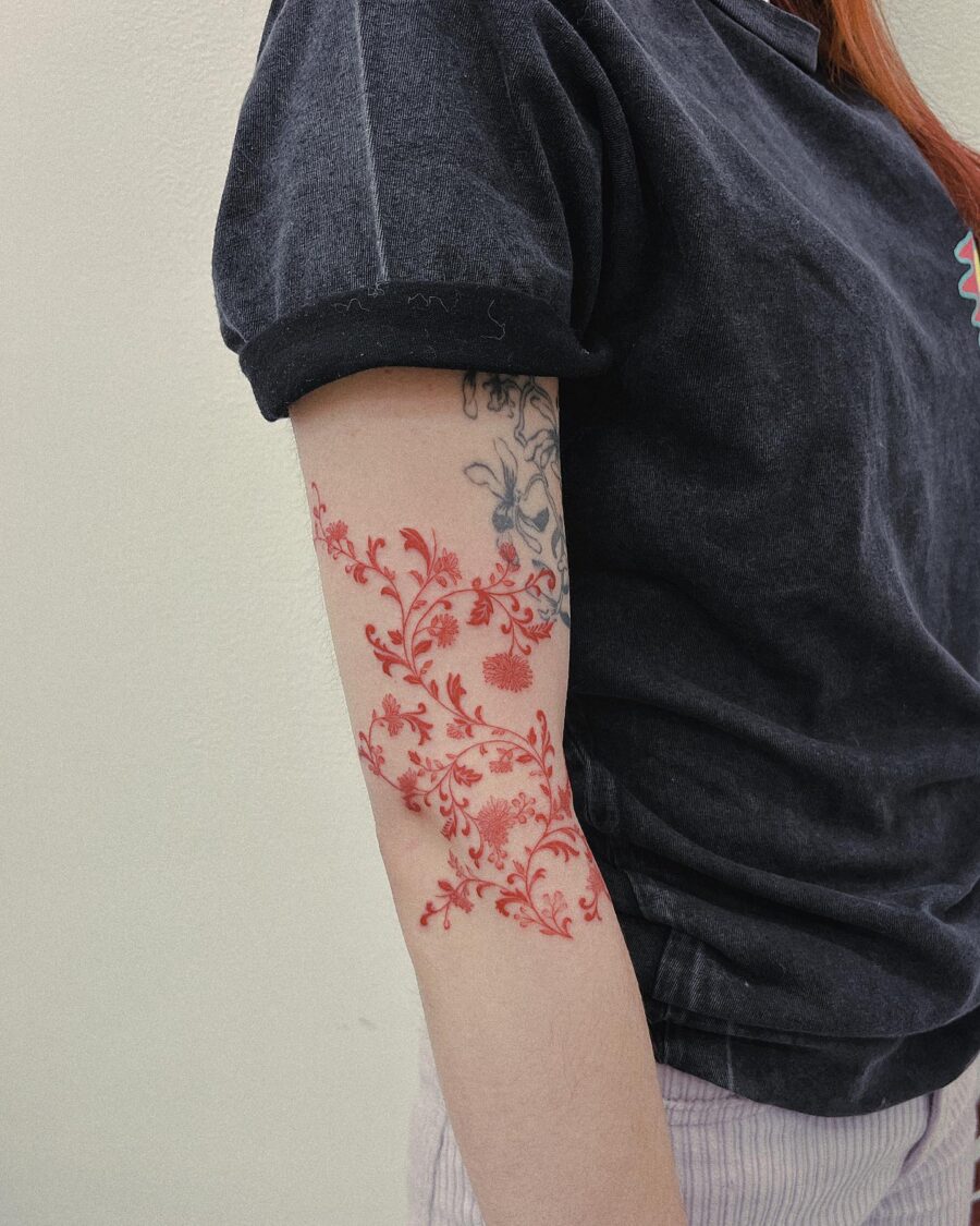 Stunning red floral tattoo on the arm