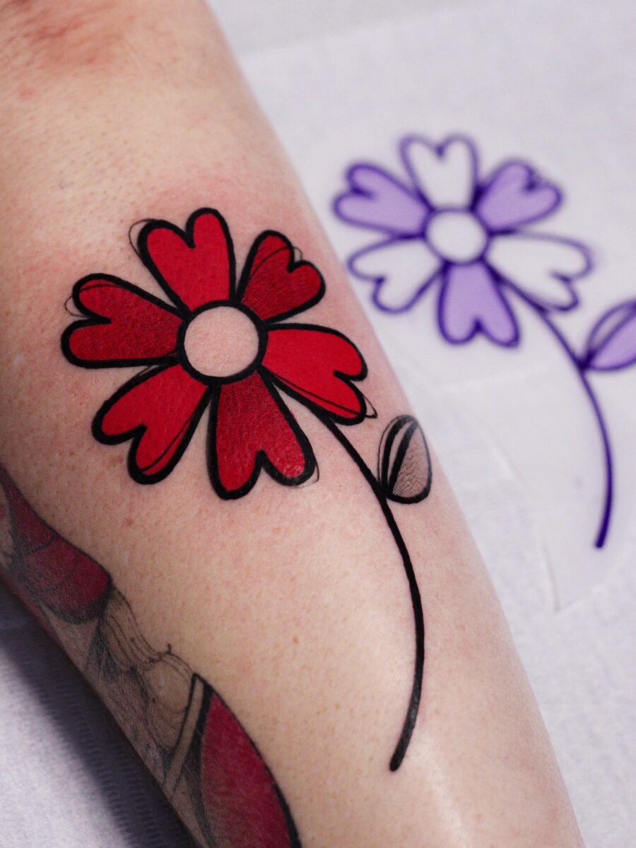 Vibrant red flower tattoo on the arm