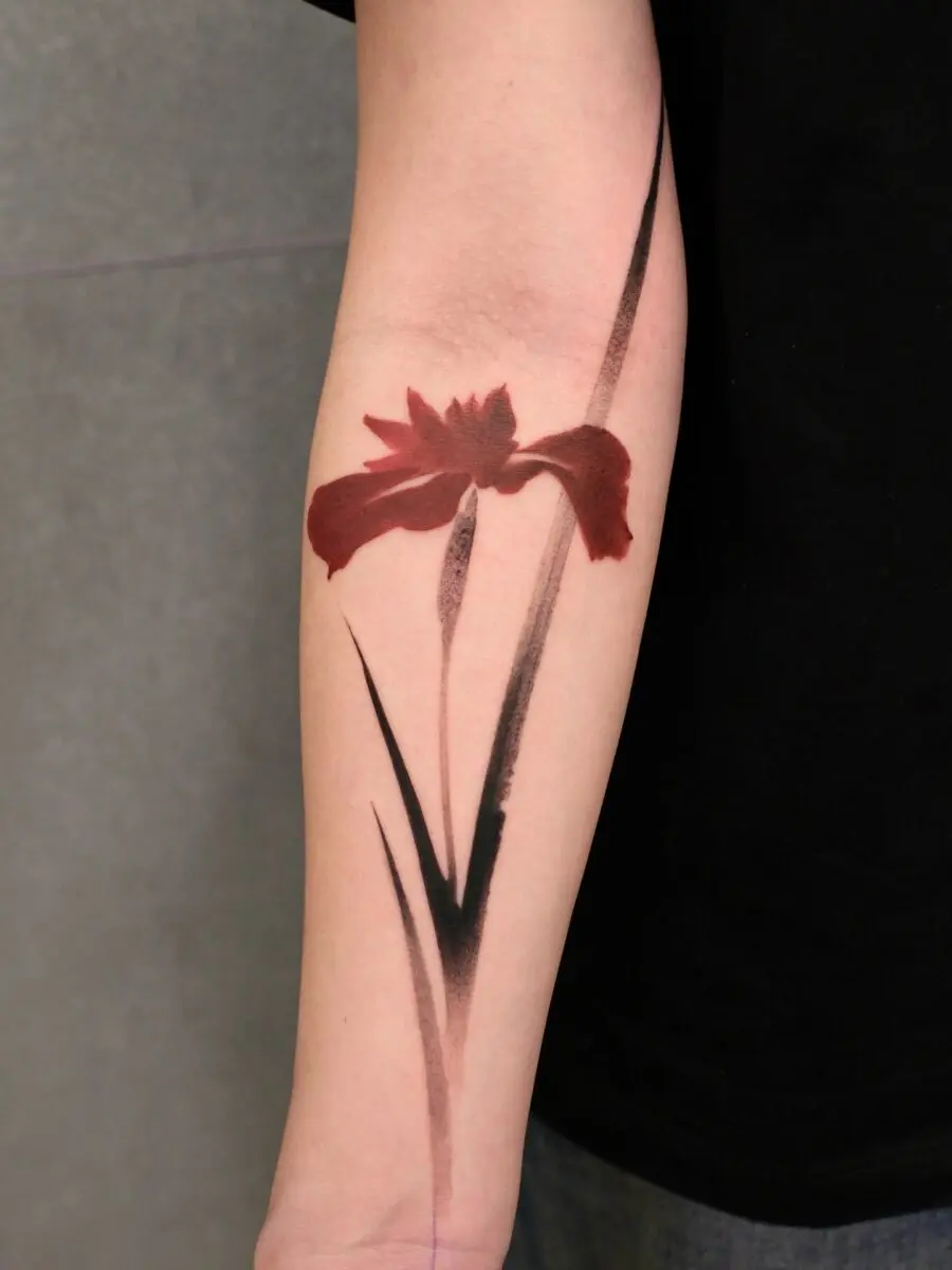 Striking red ink floral tattoo on the arm