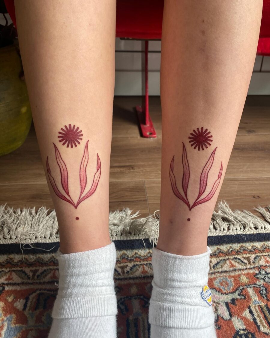 Elegant red ink floral tattoos on legs