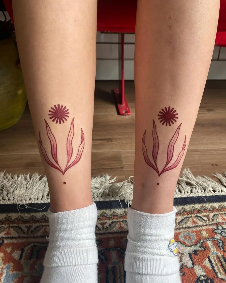 Elegant red ink floral tattoos on legs