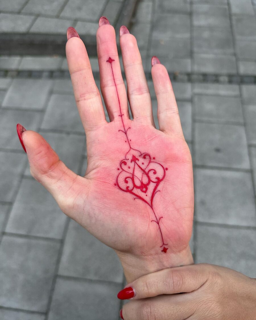 Intricate Red Ink Tattoo on the Palm