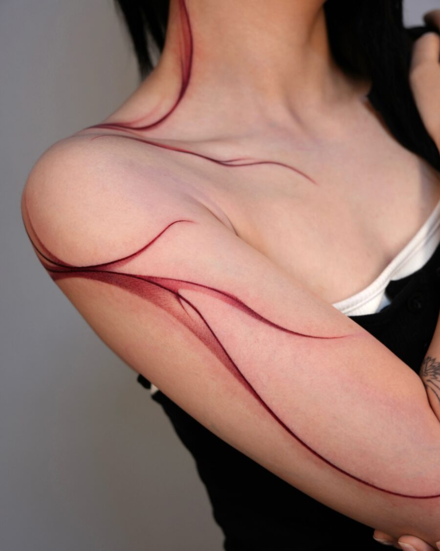 Elegant red ink tattoo with flowing lines