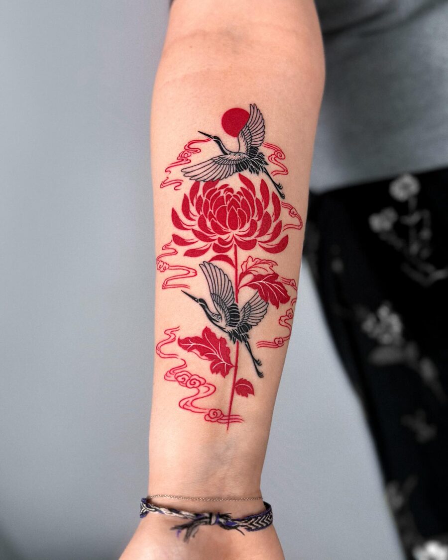 Elegant red ink tattoo featuring cranes and blooms
