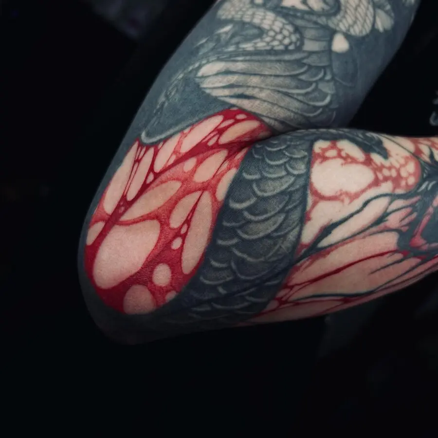 Intricate red ink tattoo design on arm