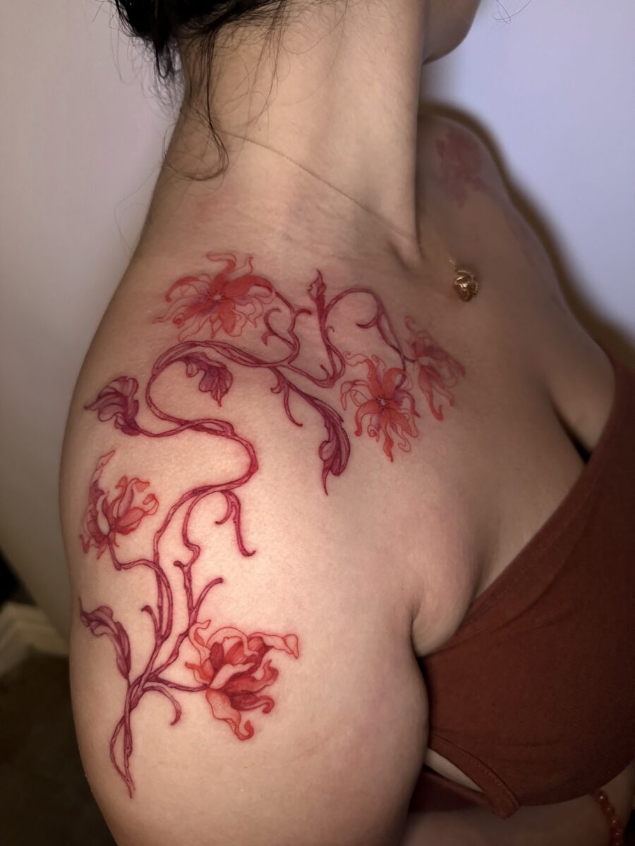 Vibrant Red Ink Floral Tattoo on the Shoulder