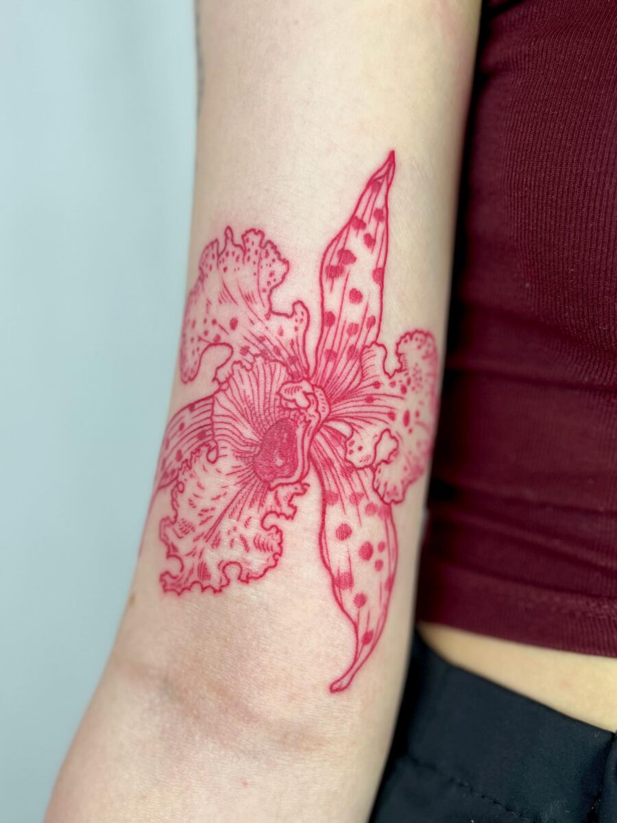 Stunning red ink floral tattoo on arm
