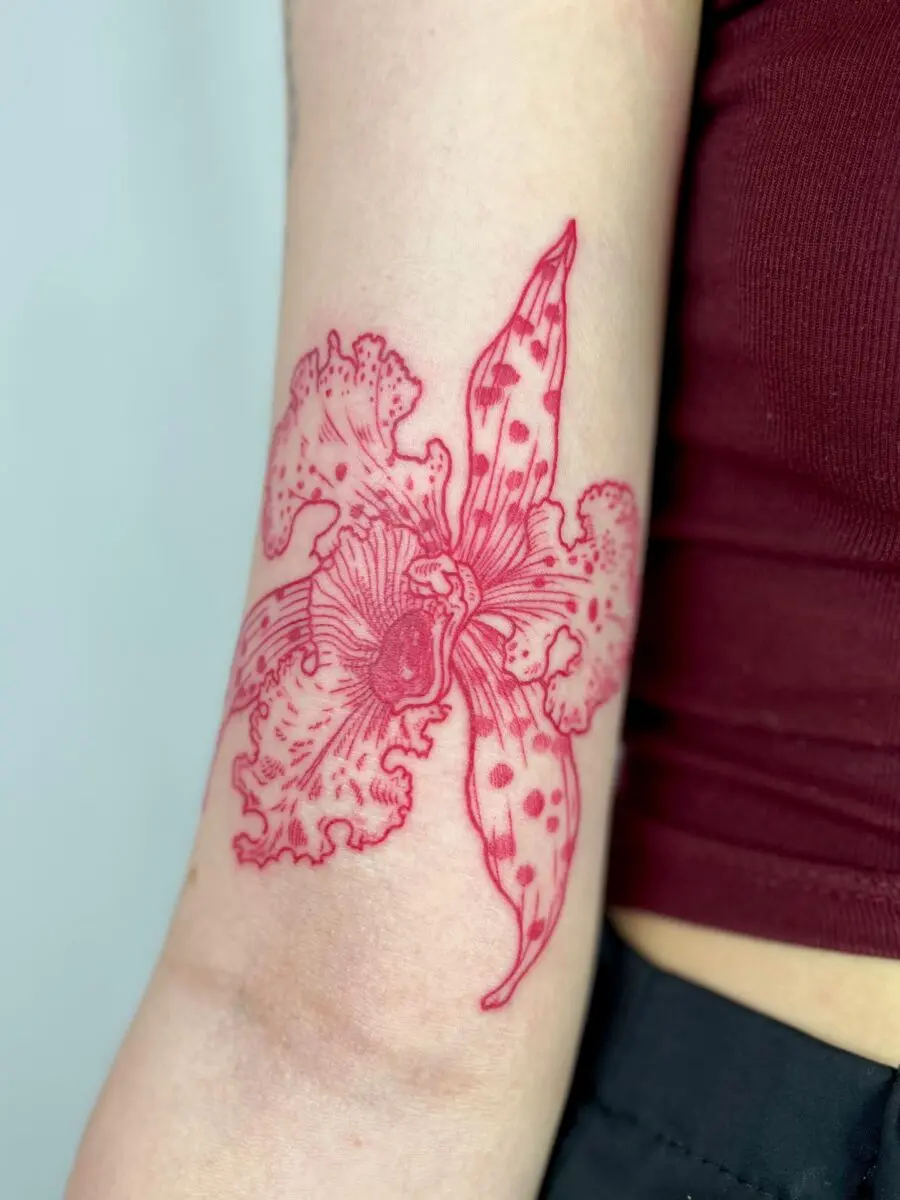 Stunning red ink floral tattoo on arm