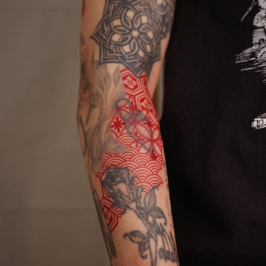 Striking red ink tattoo with floral elements