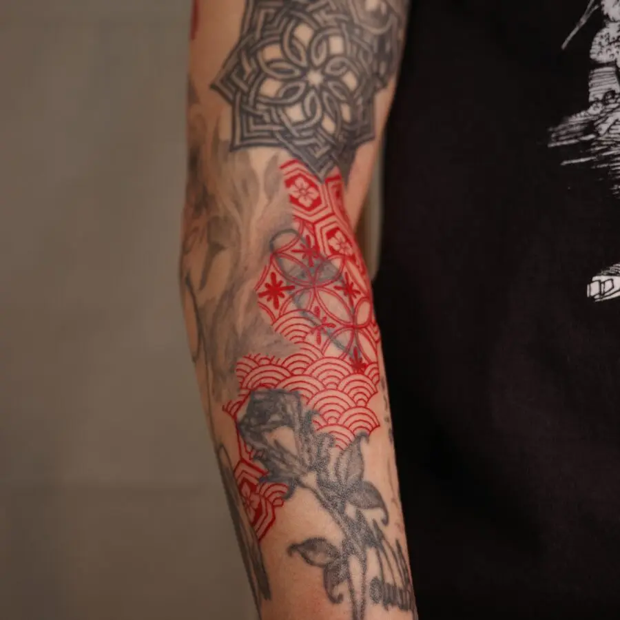 Striking red ink tattoo with floral elements