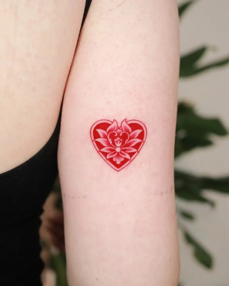 Vibrant red heart tattoo with floral accents
