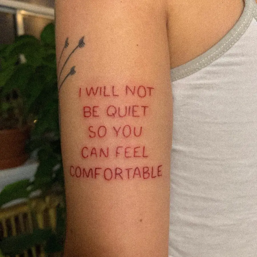 Bold red ink tattoo featuring a powerful quote