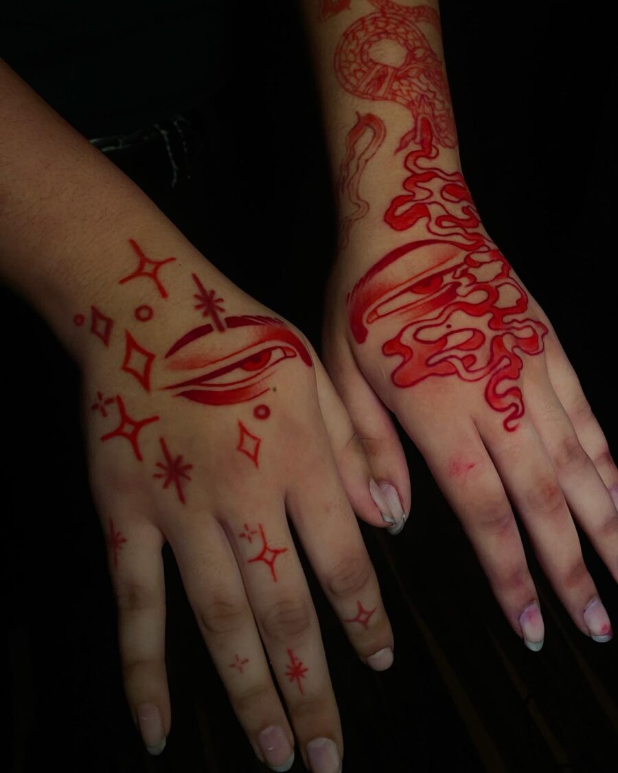 Intricate red ink designs on hands and arms