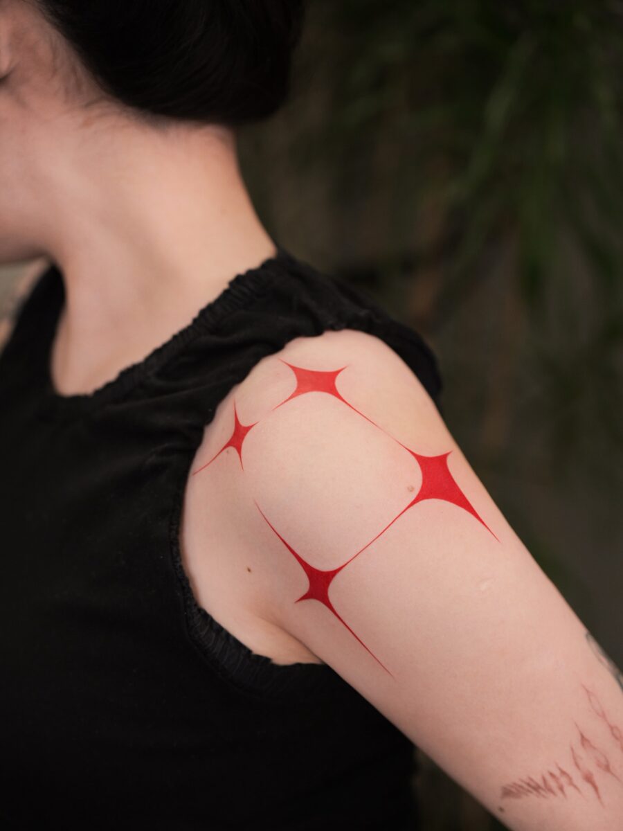 Striking Red Ink Tattoo Design on Shoulder