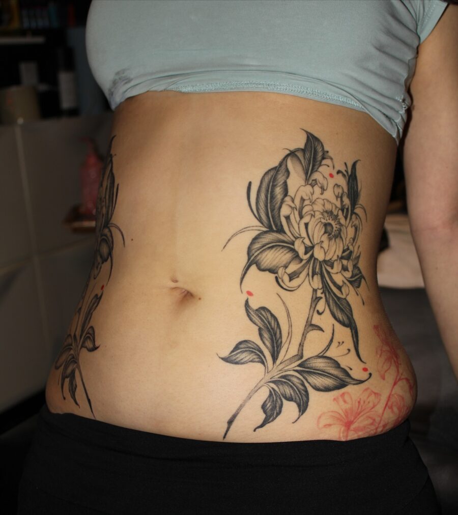 Elegant floral stomach tattoo with bold lines