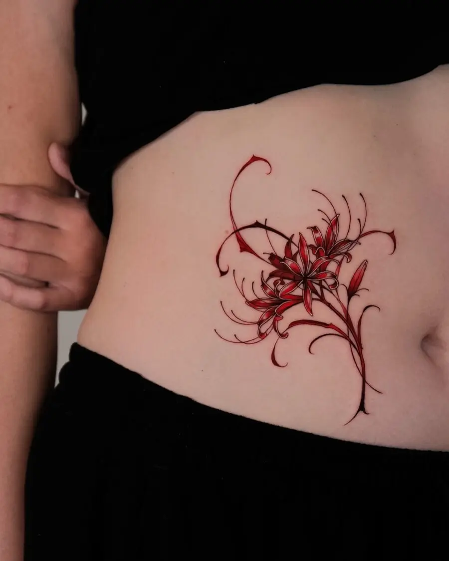 Vibrant floral stomach tattoo in red hues