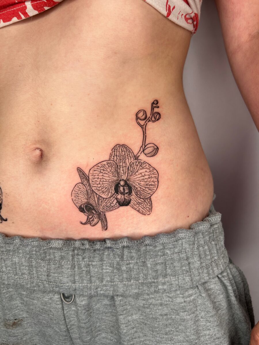 Elegant orchid tattoo on the stomach