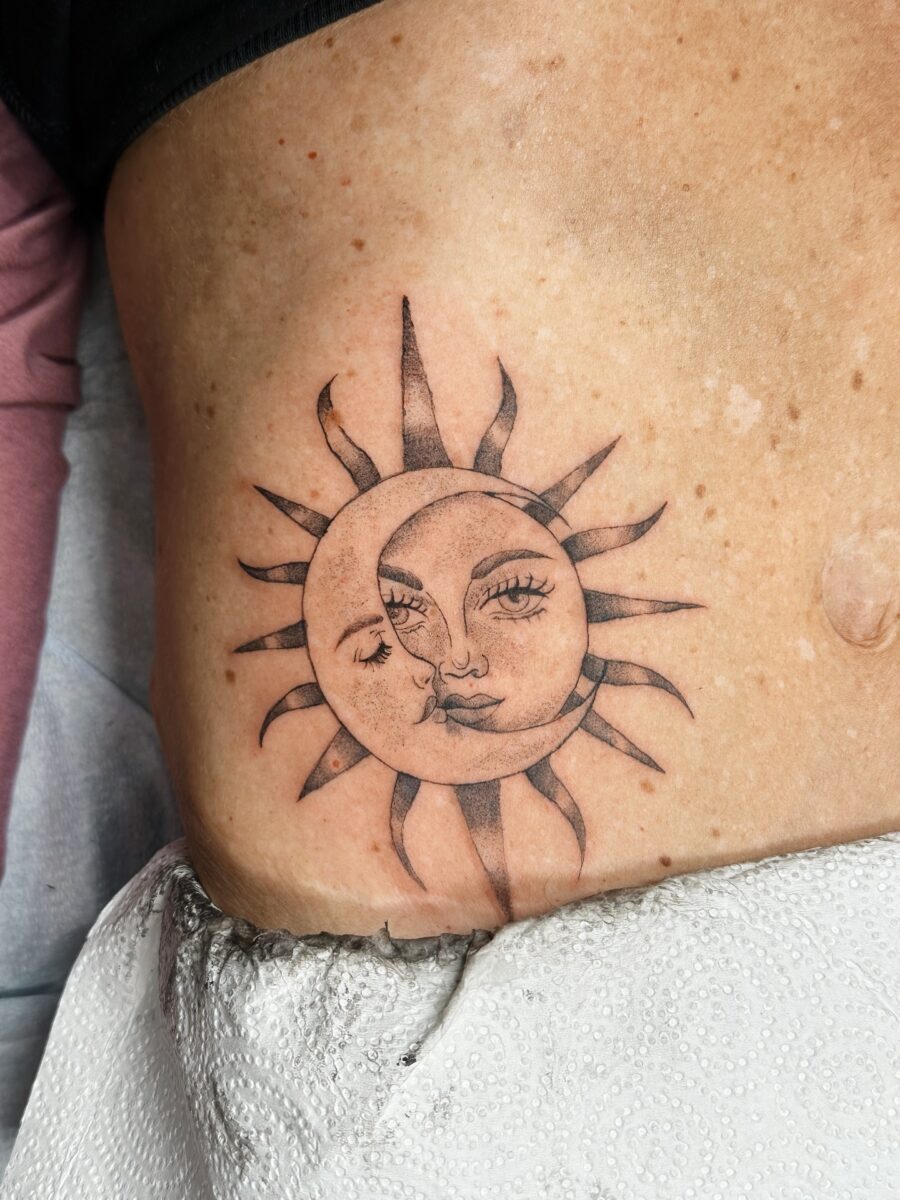 Intricate sun and moon face tattoo design