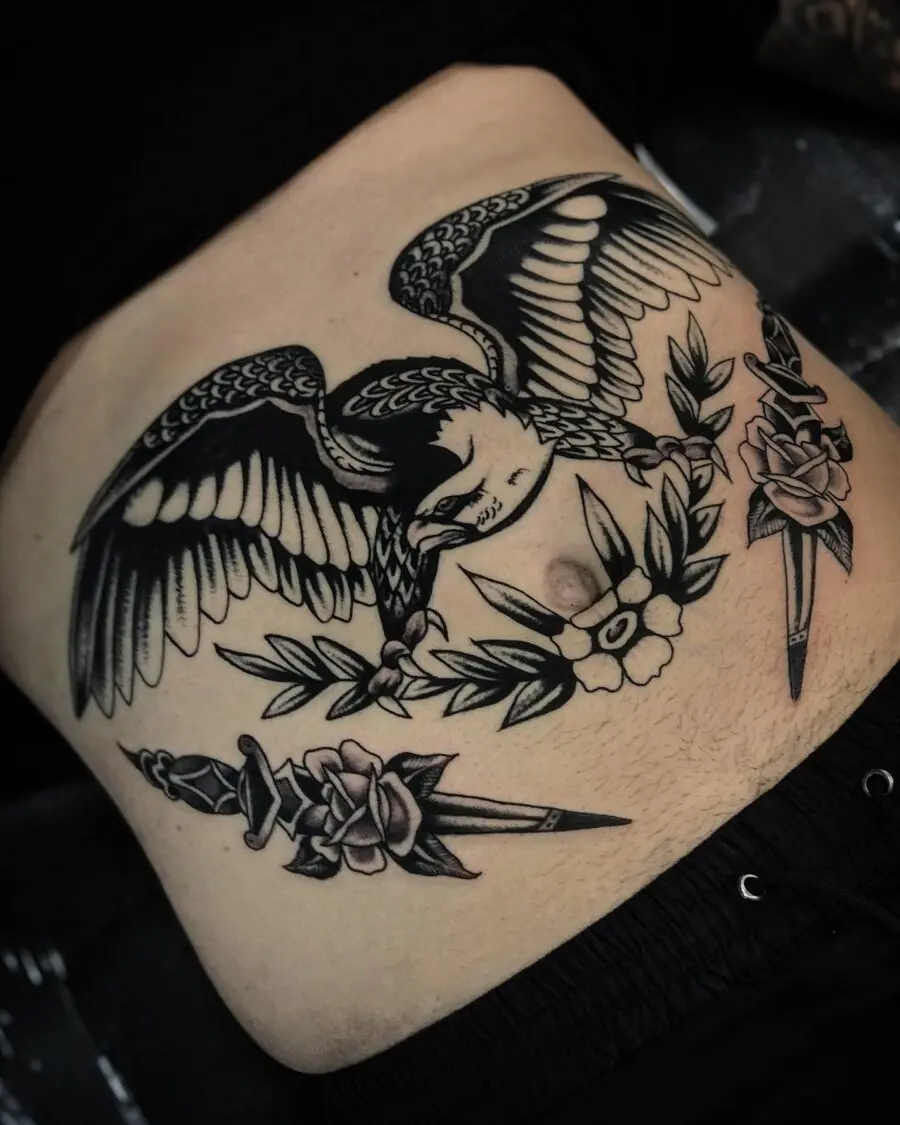 Bold stomach tattoo featuring bird and flowers