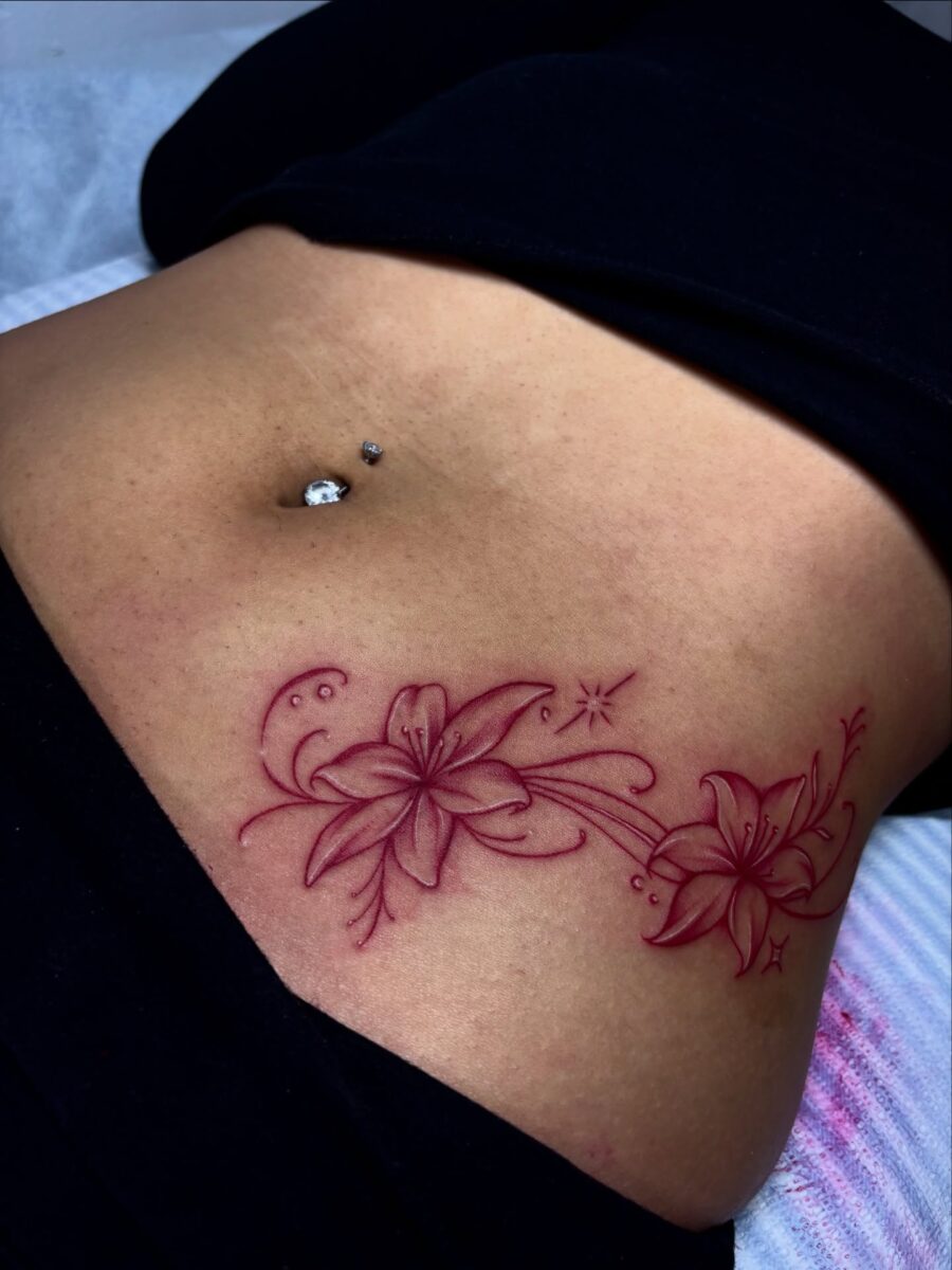 Elegant floral stomach tattoo in vibrant red