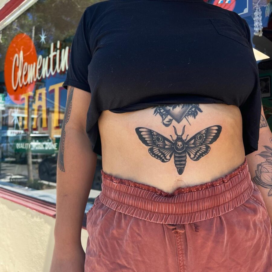 Intricate stomach tattoo featuring a striking moth.
