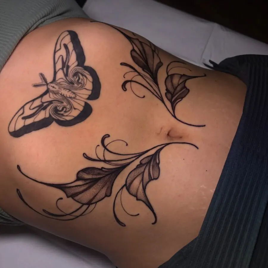 Delicate moth and leaves stomach tattoo design