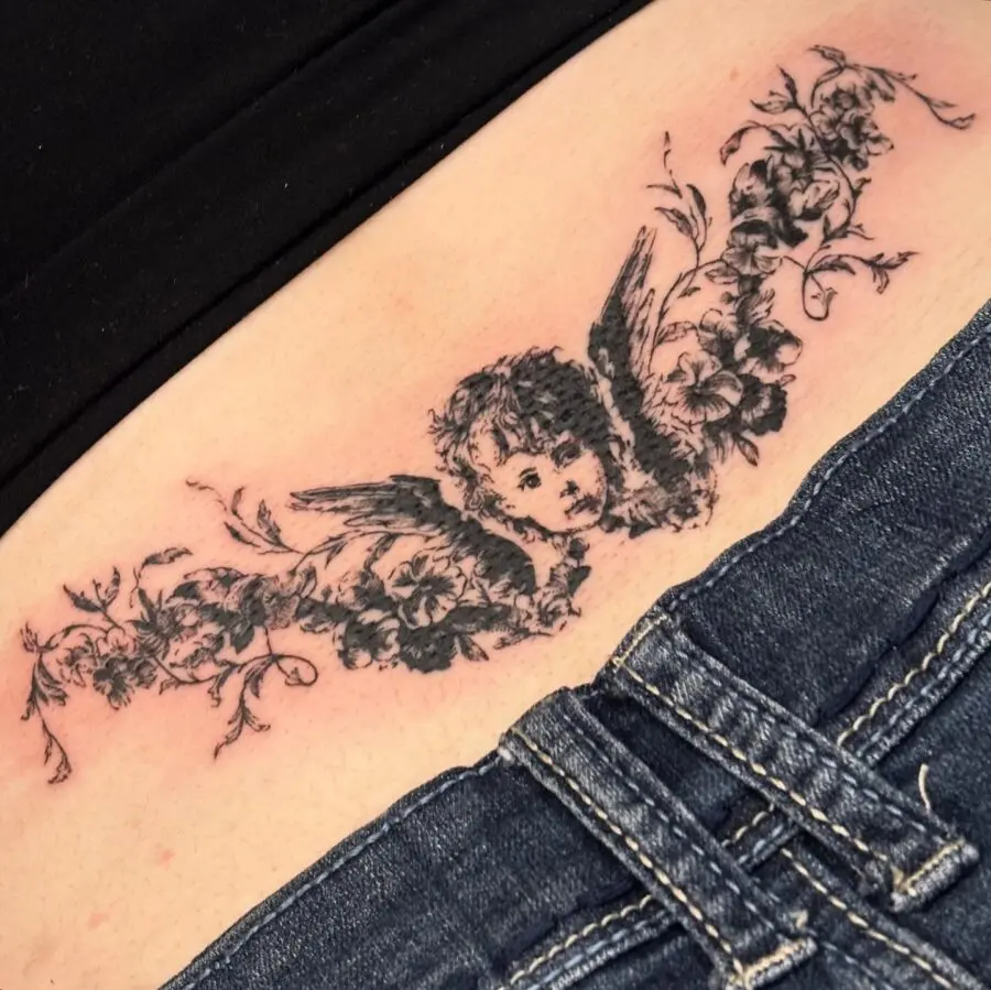 Stylish angel and floral tramp stamp tattoo