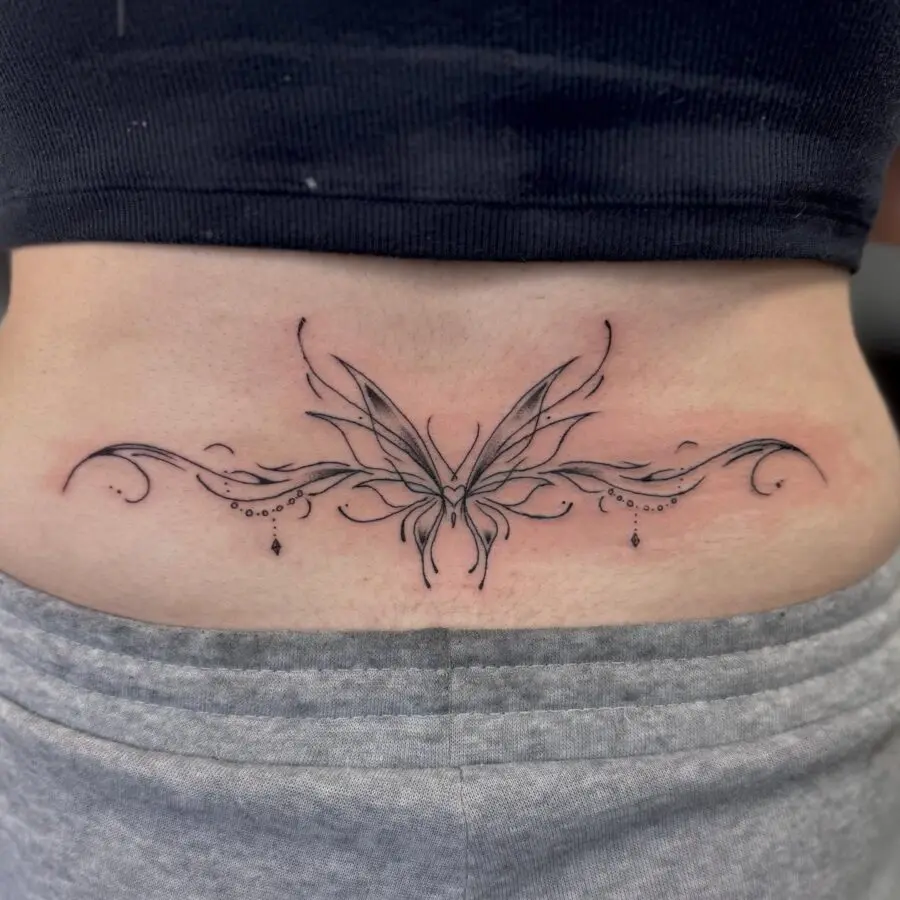 Elegant butterfly tattoo with decorative swirls