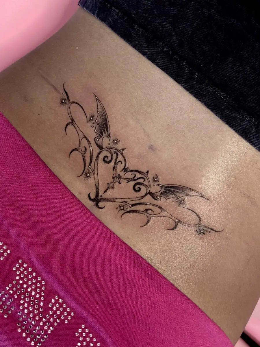 Intricate tramp stamp with whimsical bat details
