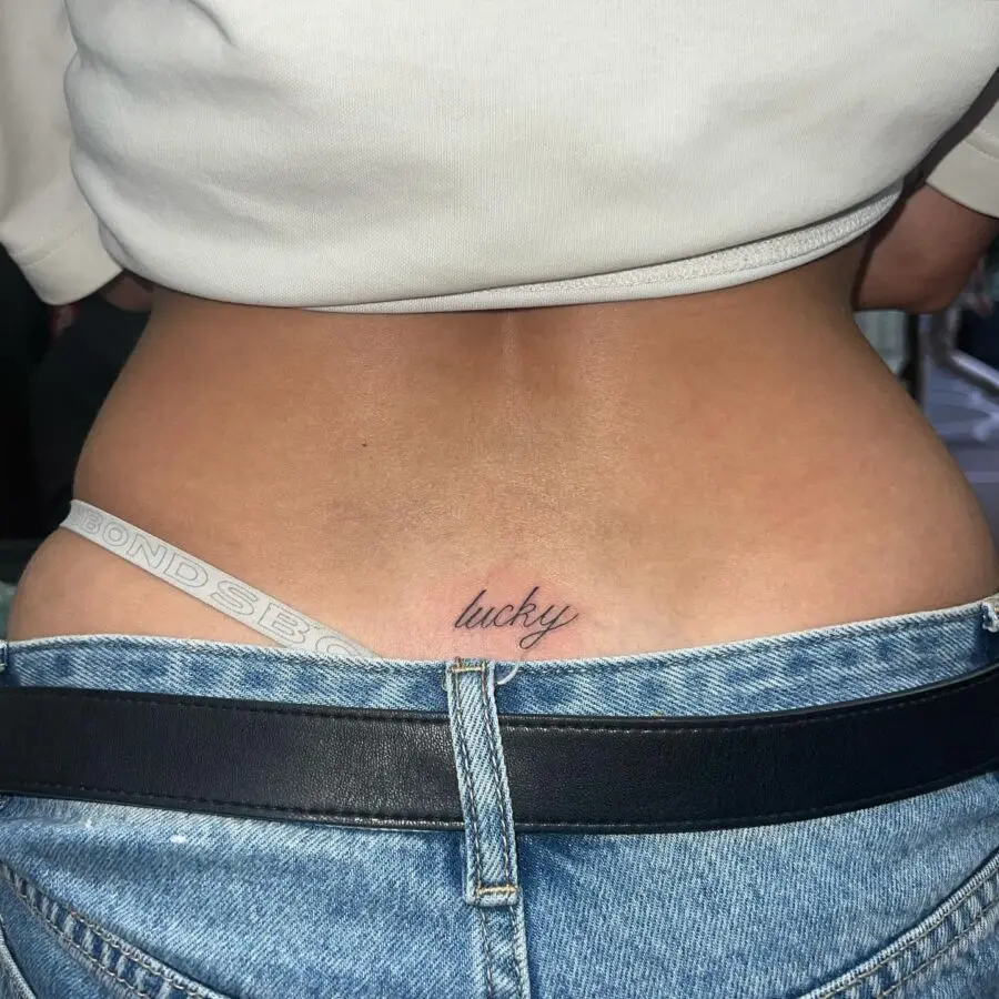 Elegant lucky script tramp stamp tattoo design