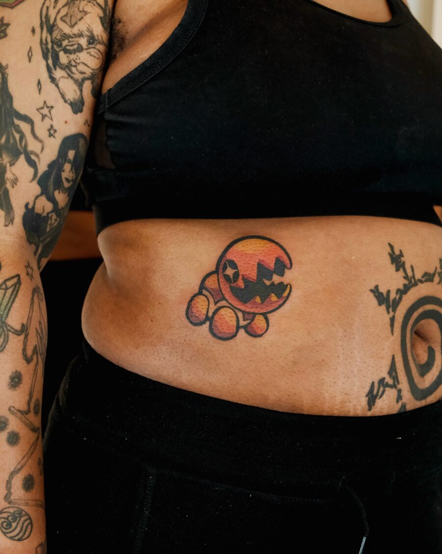 Playful cartoon-inspired stomach tattoo design