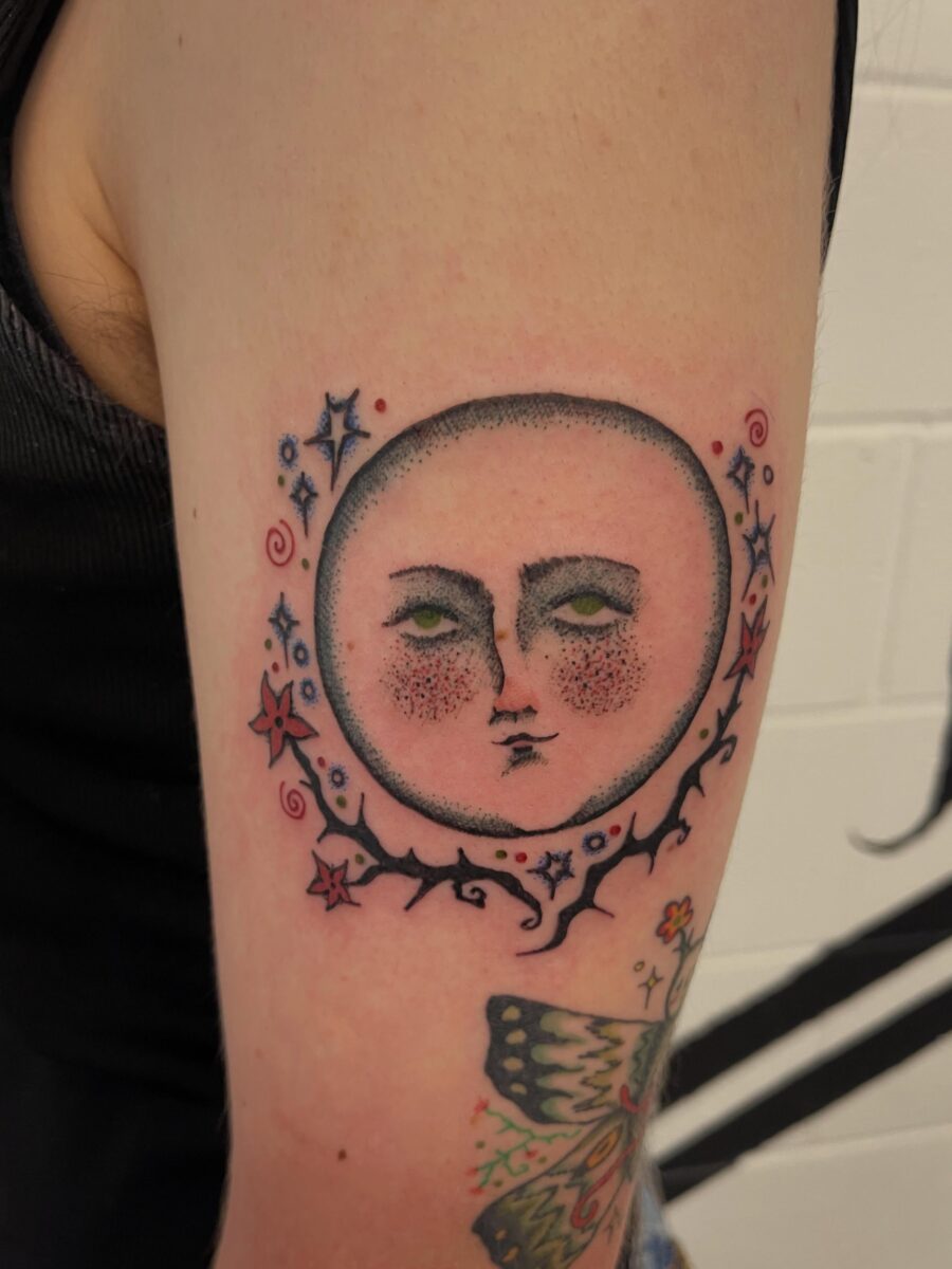 Enchanting moon face tattoo with whimsical details