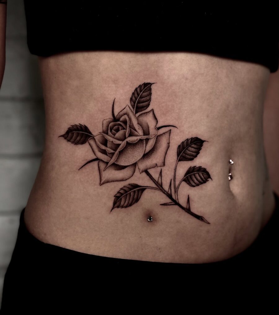 Elegant black rose tattoo on the stomach
