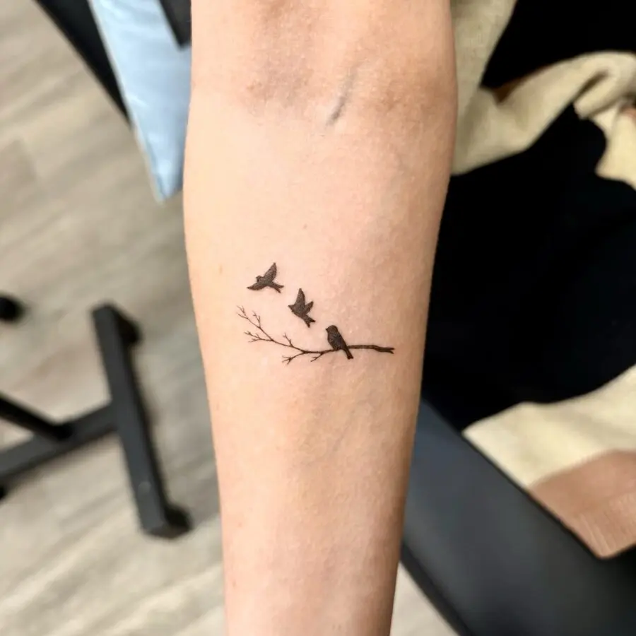 Elegant tattoo honoring loved ones with birds