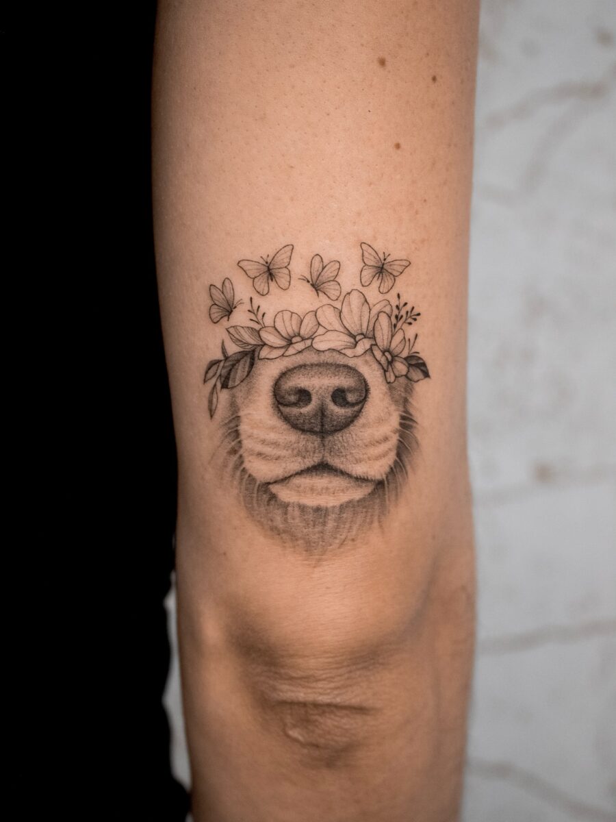 Beautiful dog tattoo with floral and butterfly accents