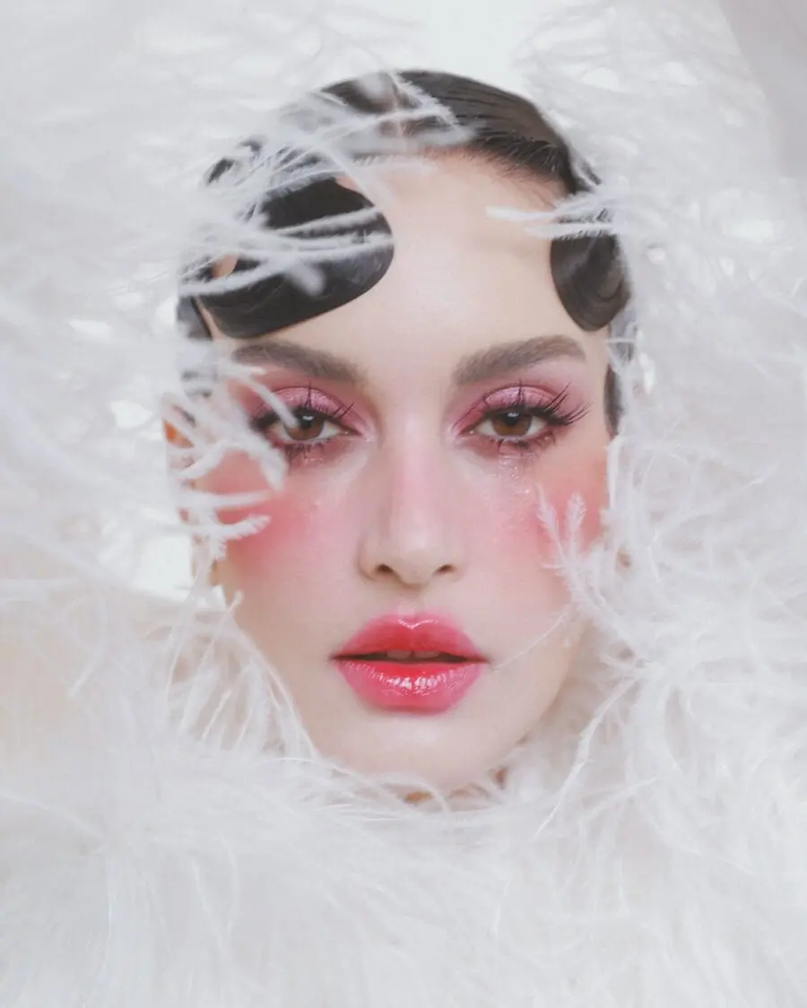 Whimsical doll-inspired makeup with soft glam.