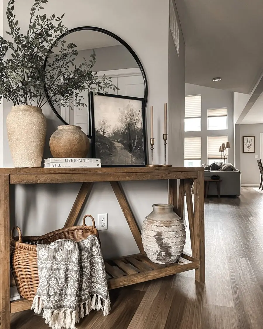 Stylish entryway table with greenery and art