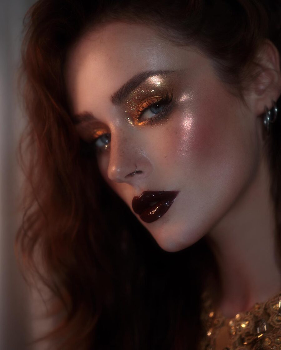 Glistening gold and bold dark lip look