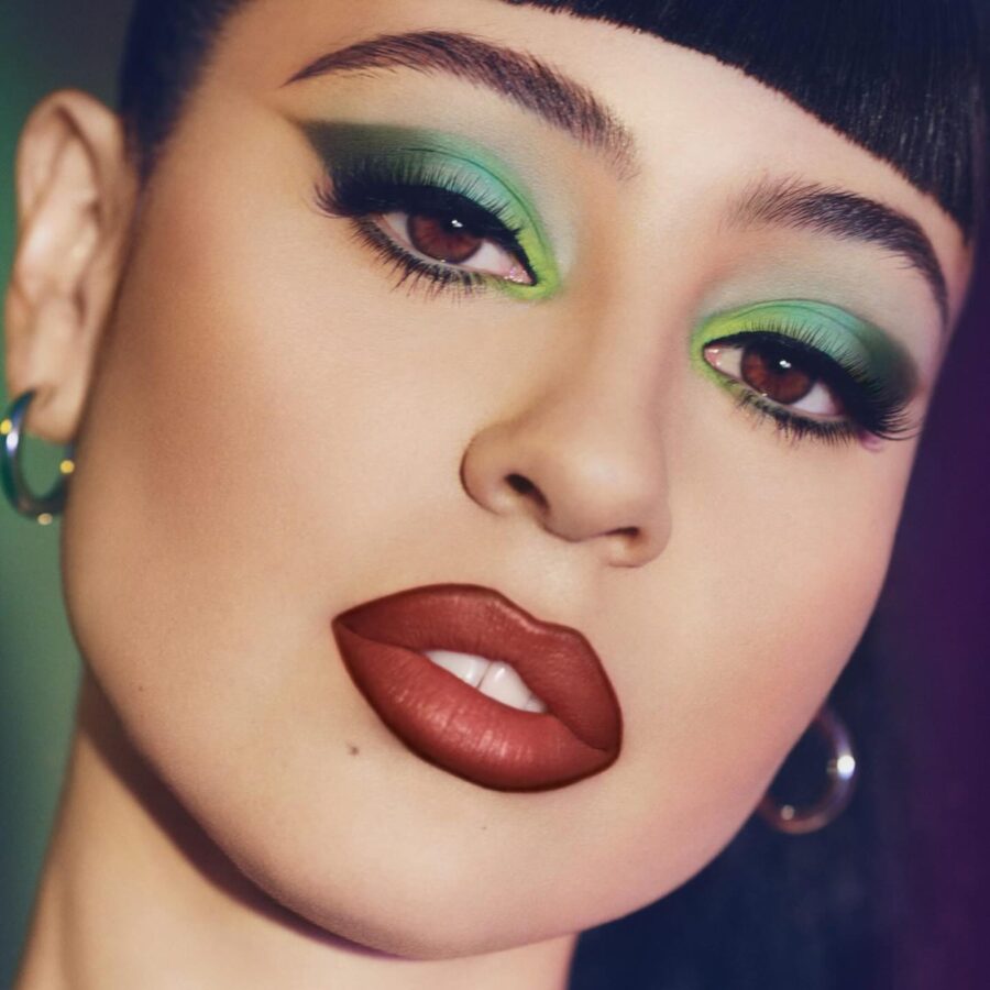 Vibrant green eyes and bold lips unite.