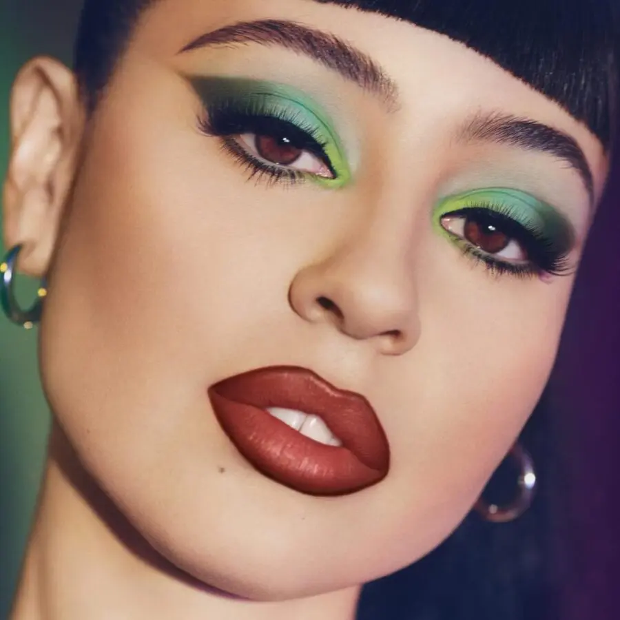 Vibrant green eyes and bold lips unite.