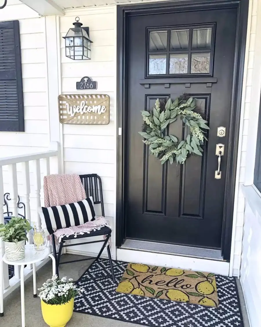 Charming entrance with black door and greenery