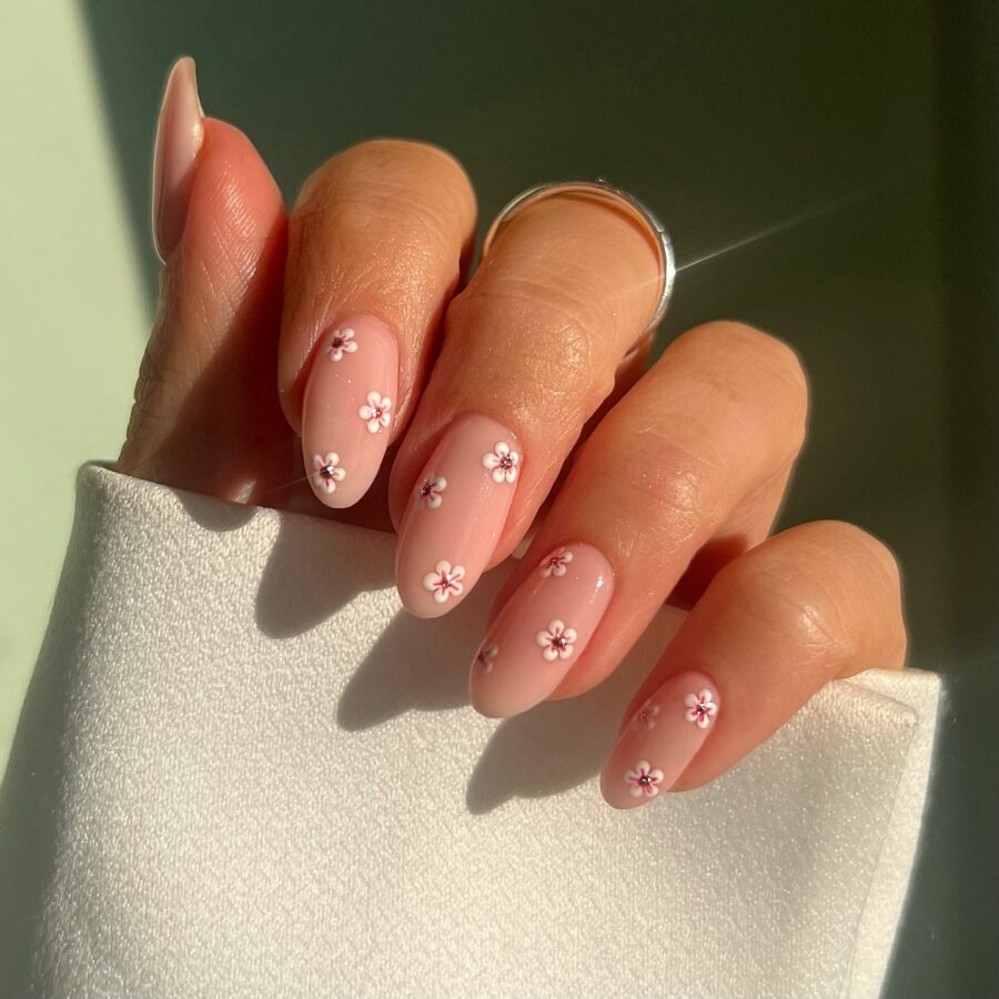 Delicate pink nails adorned with tiny flowers