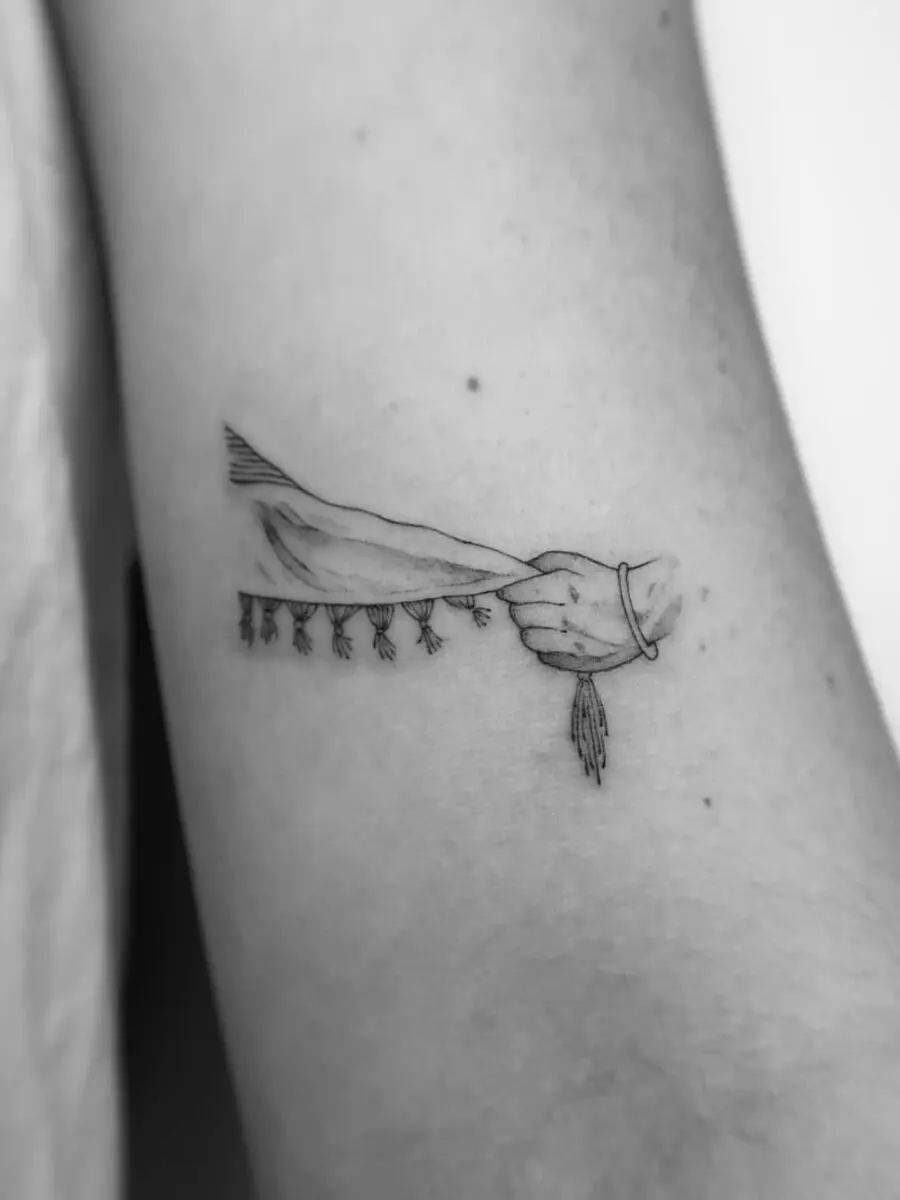 Elegant hand tattoo with tassels detail