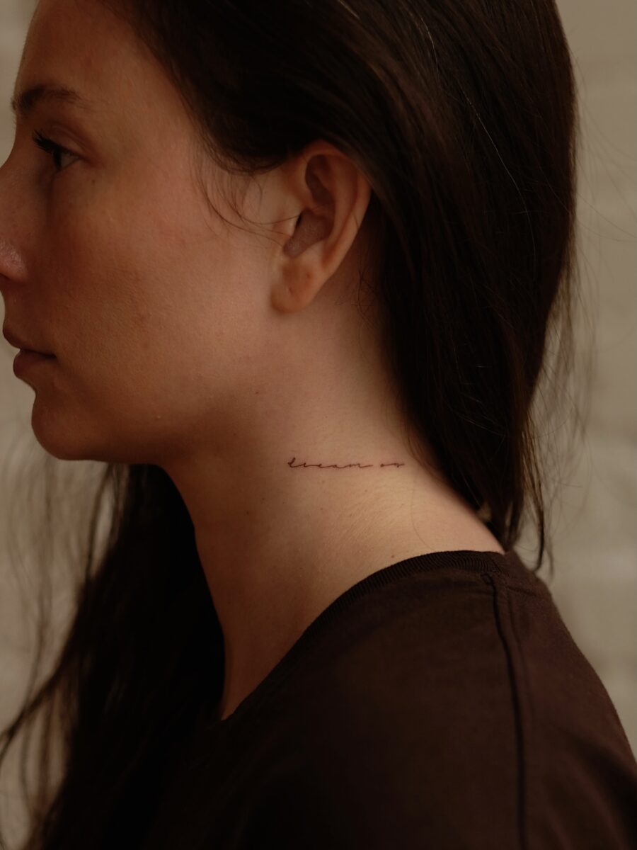 Elegant script tattoo on the neck