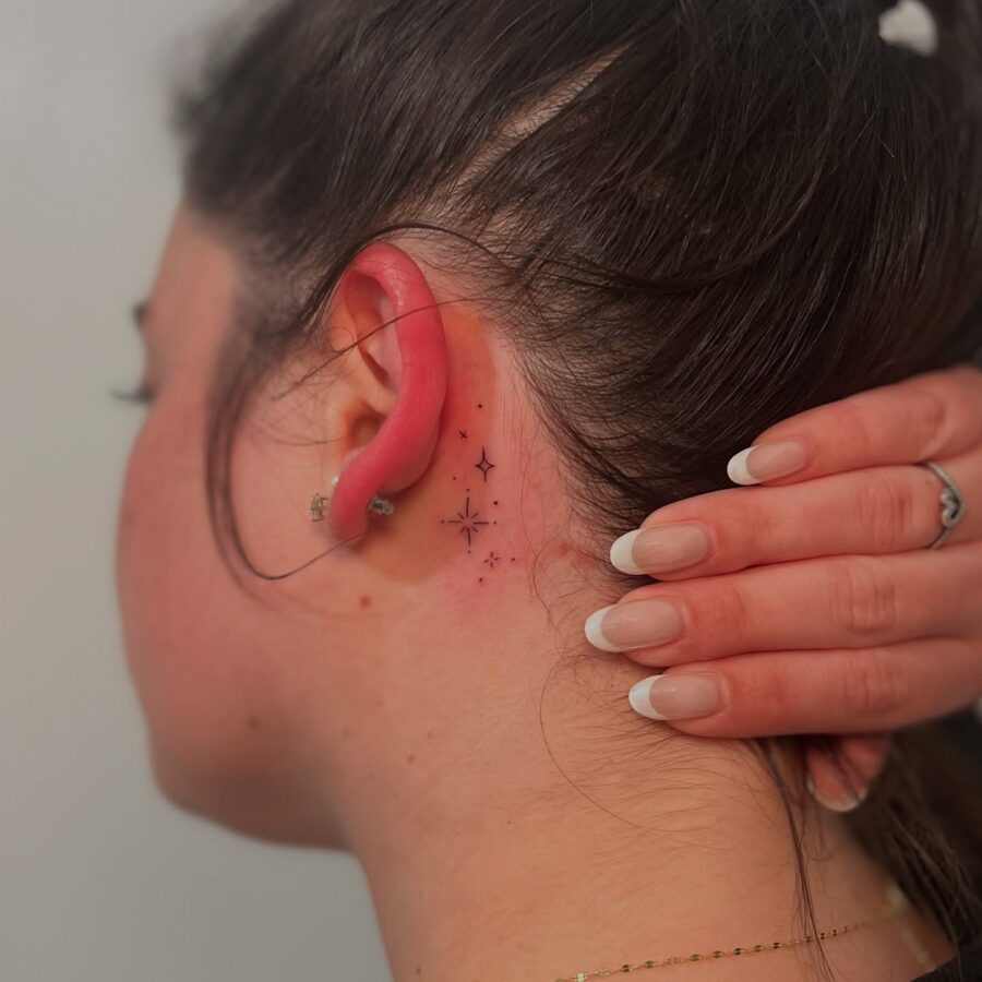 Delicate stars tattoo hidden behind the ear