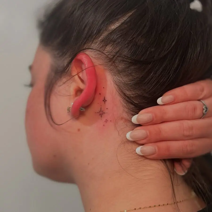 Delicate stars tattoo hidden behind the ear