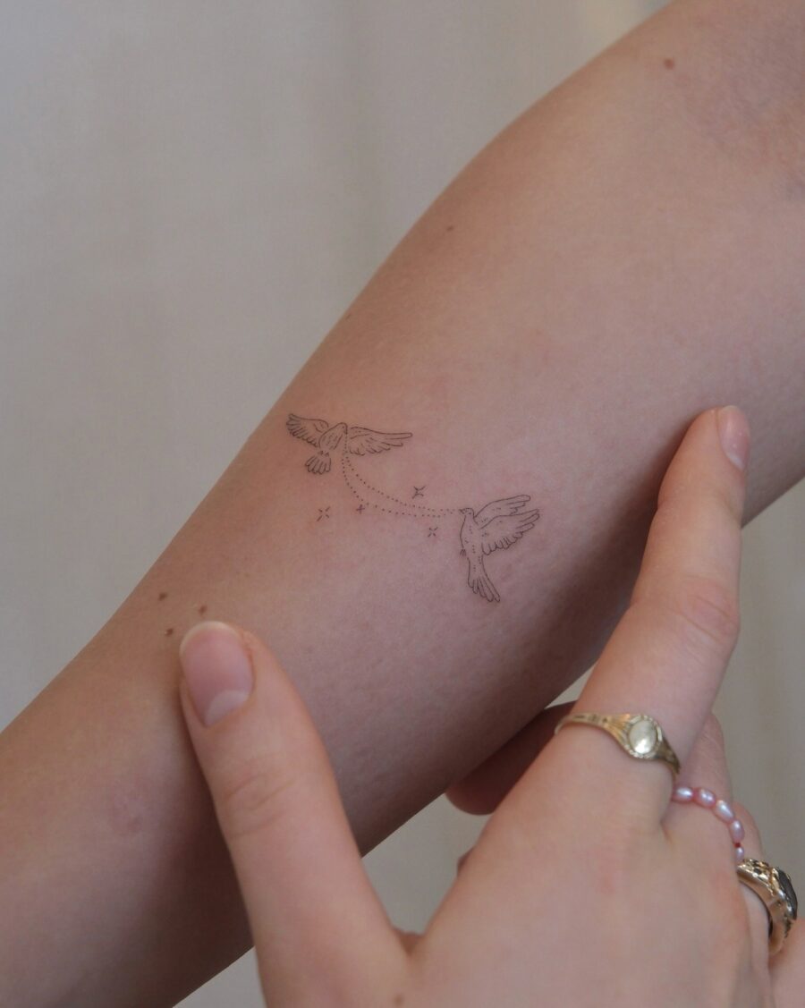 Elegant birds in subtle flight tattoo design